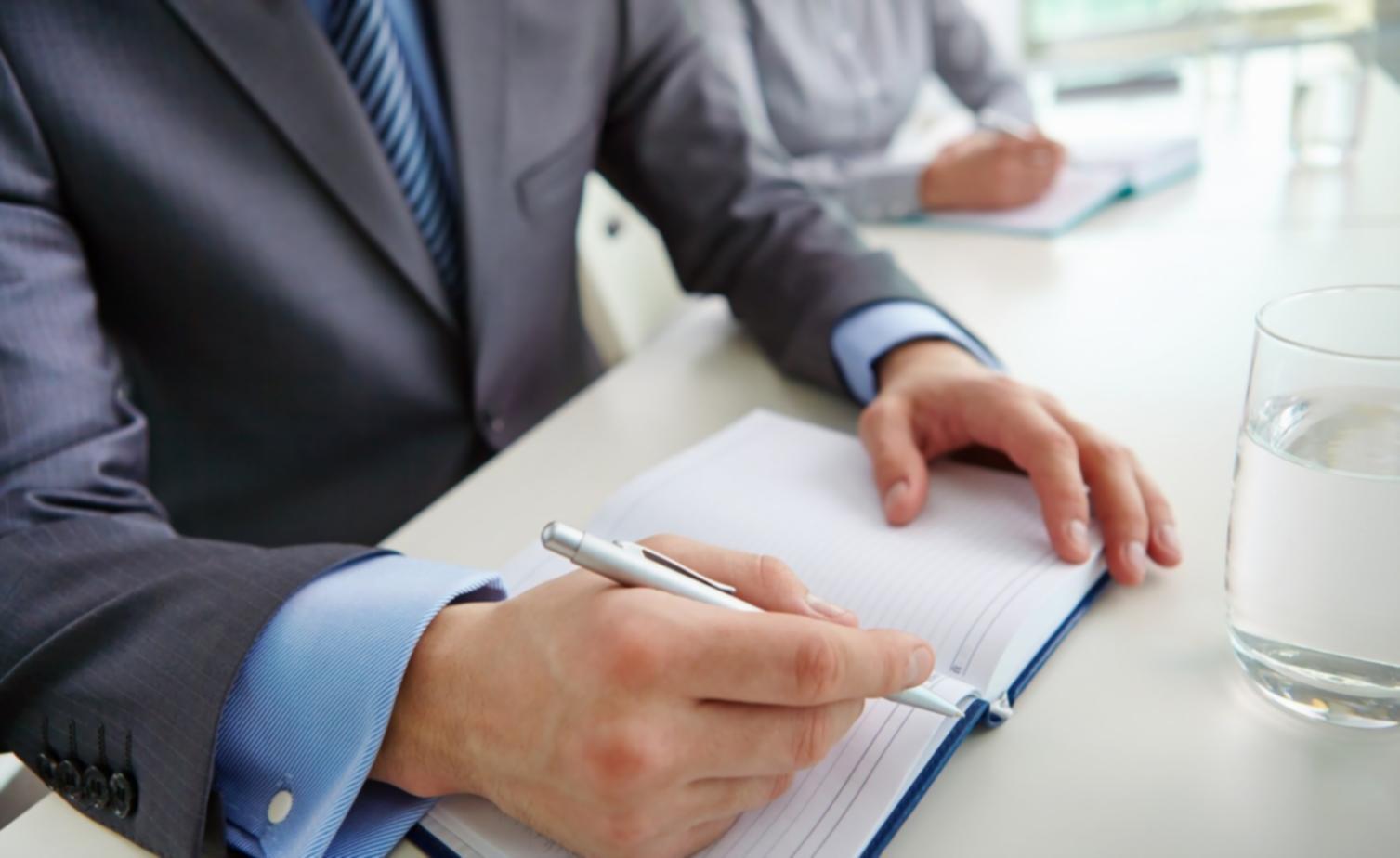 Estudiante internacional trabajando en análisis financiero con documentos y laptop
